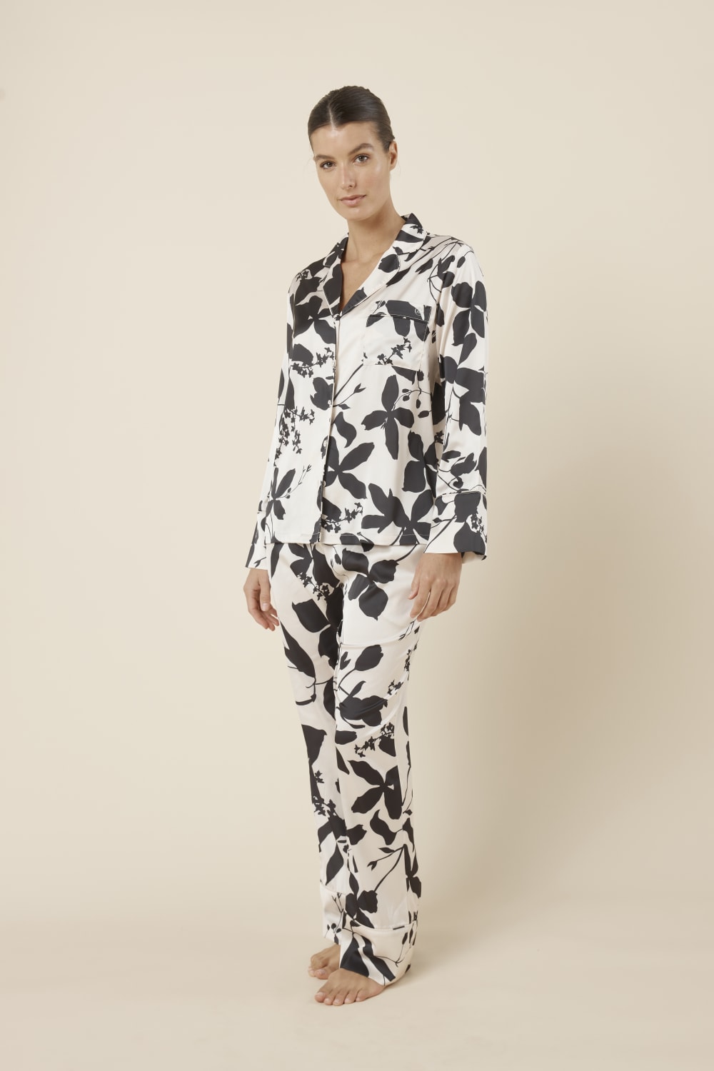 Woman wearing a black and white floral ivy silky satin pyjama PJ set side on view
