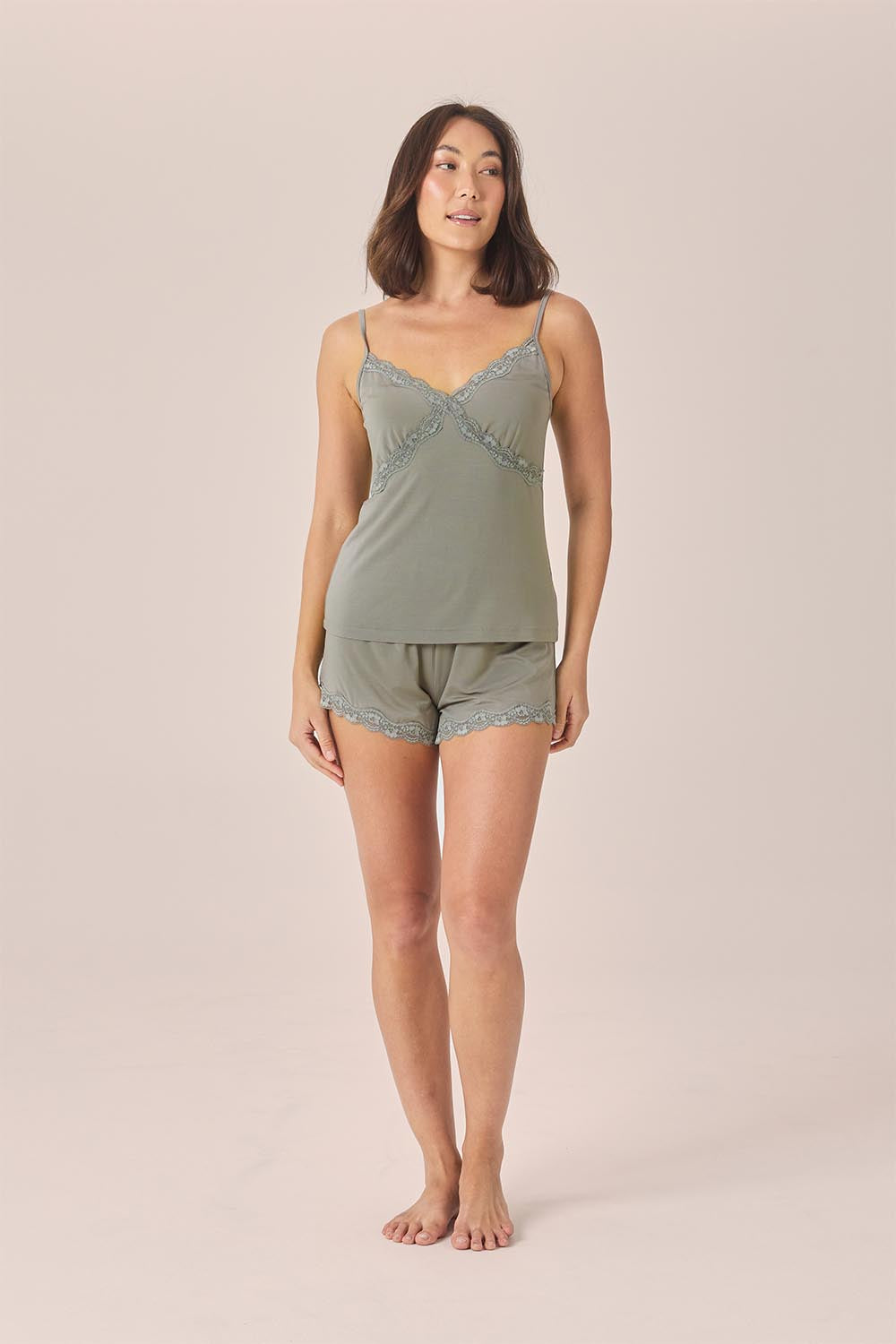 Woman wearing the Mabel Bamboo Cami and Short Set in Olive, front view of lace-trim cami and shorts