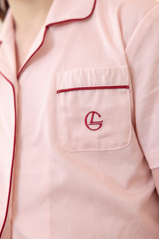 Pink shirt with a red logo on the chest pocket