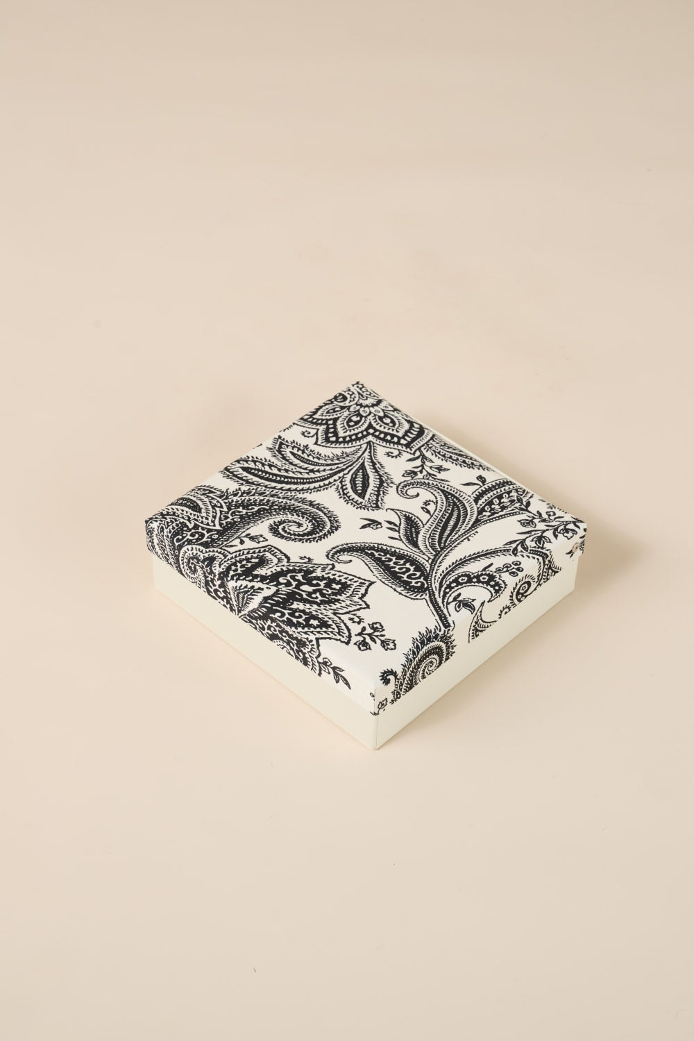 Black paisley patterned box on a beige background