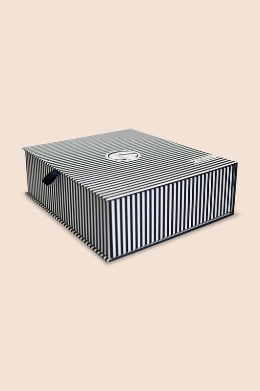 Black and white striped shoe box on a beige background