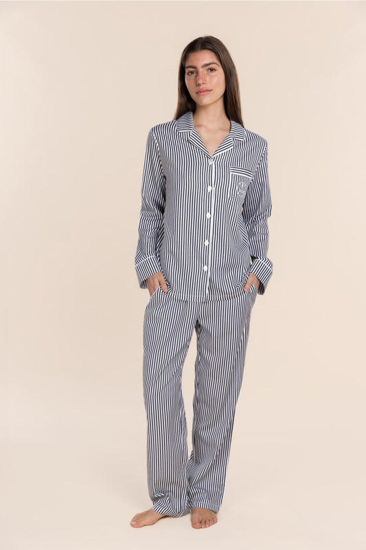 Woman wearing a striped pajama set on a beige background