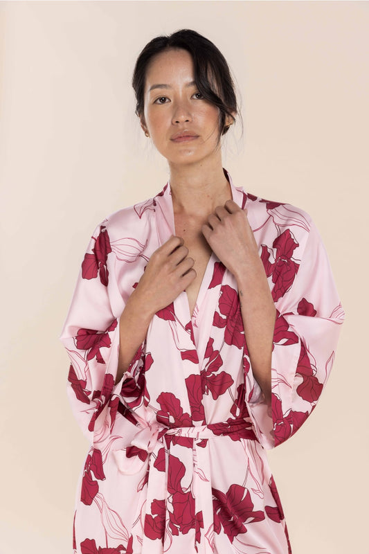 Woman wearing a pink floral robe against a beige background