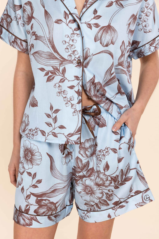 Light blue pajama set with brown floral pattern on a beige background