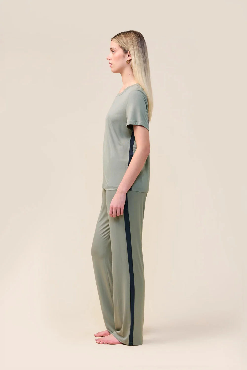 Woman wearing the Inez Bamboo Pant with Stripe in Olive, side view showing the contrast side stripe