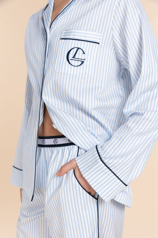 Light blue pinstripe pajama set with a logo on a beige background