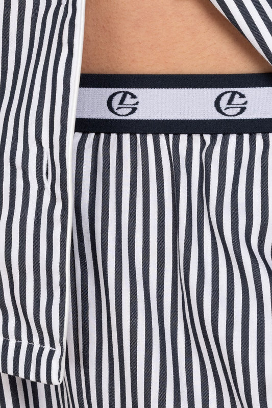 Close-up of navy and white striped pyjama pants with a brand logo on the waistband.