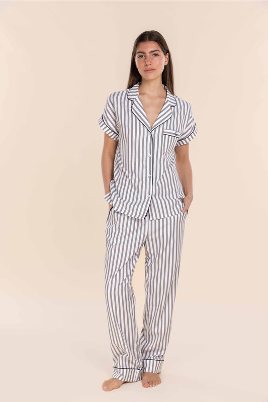 Woman wearing a striped pajama set on a beige background