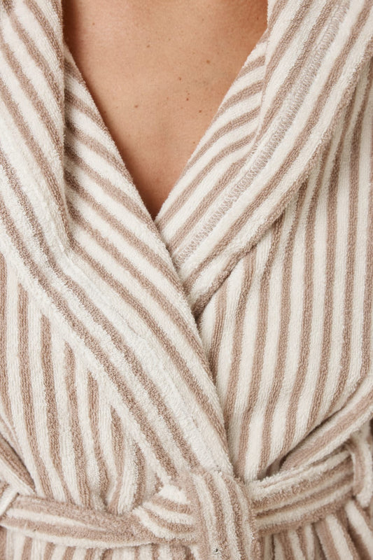 Detail of fabric of woman wearing a striped adriana terry towel robe in biscuit colour showing the robe tie
