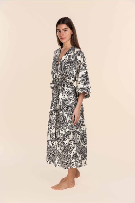 Woman wearing a black and white patterned robe on a beige background