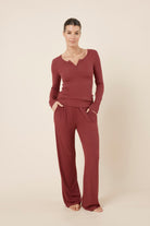 Woman wearing a Athens ribbed Long pant from the front on view with hands in pockets looking relaxed