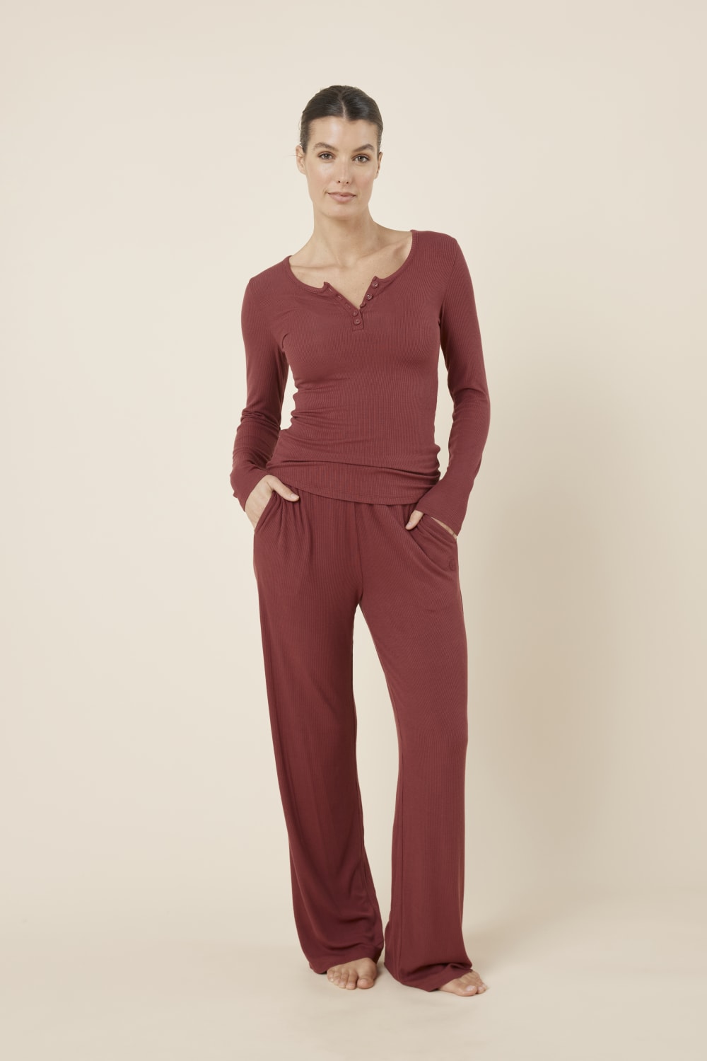 Woman wearing a Athens ribbed Long pant from the front on view with hands in pockets looking relaxed