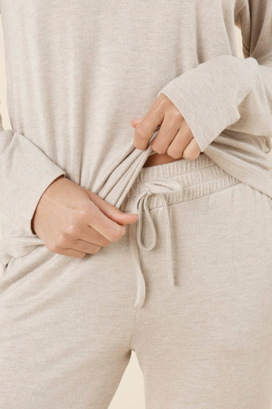 Person wearing brianna lounge set oatmeal front and hands adjusting the drawstring.