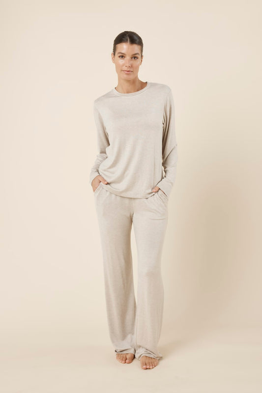 Woman wearing a brianna lounge set oatmeal on a plain beige background with hands in pockets