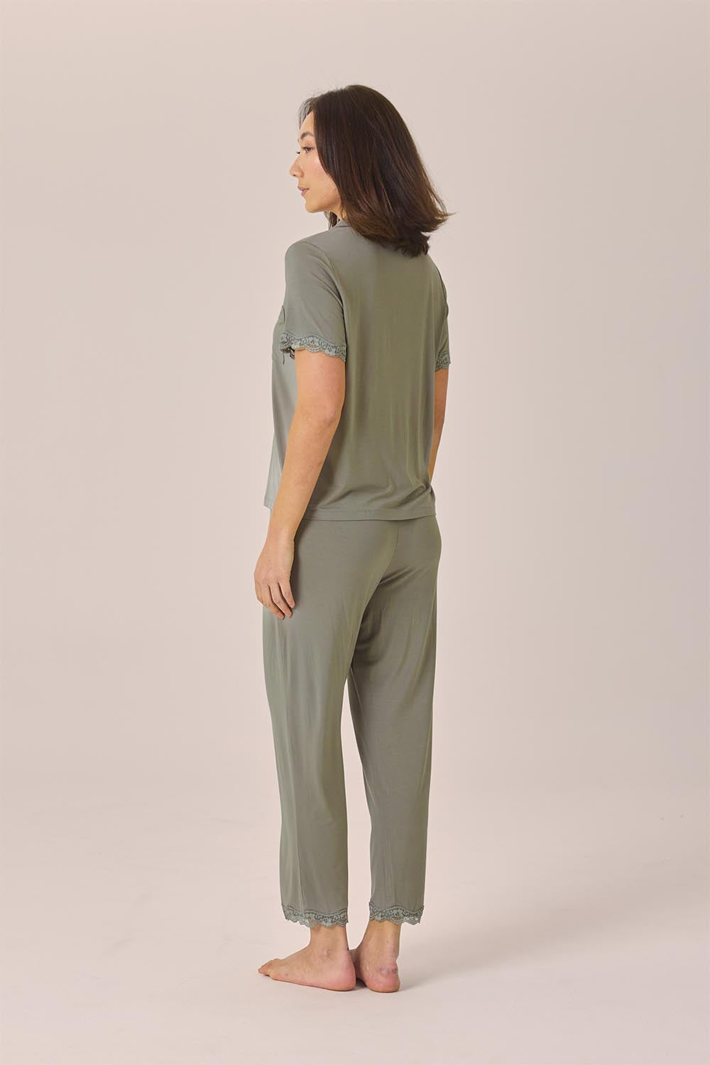 Woman wearing the Dianne Bamboo Long PJ Set with Lace in Olive, angled back view