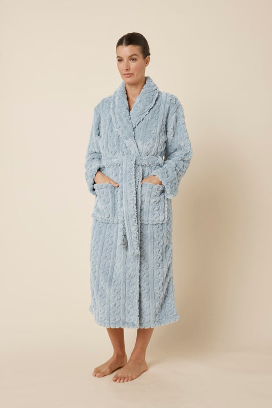 Woman wearing a textured blue Gabriella Plush Long Robe with her hands in both pockets and waist tie done up