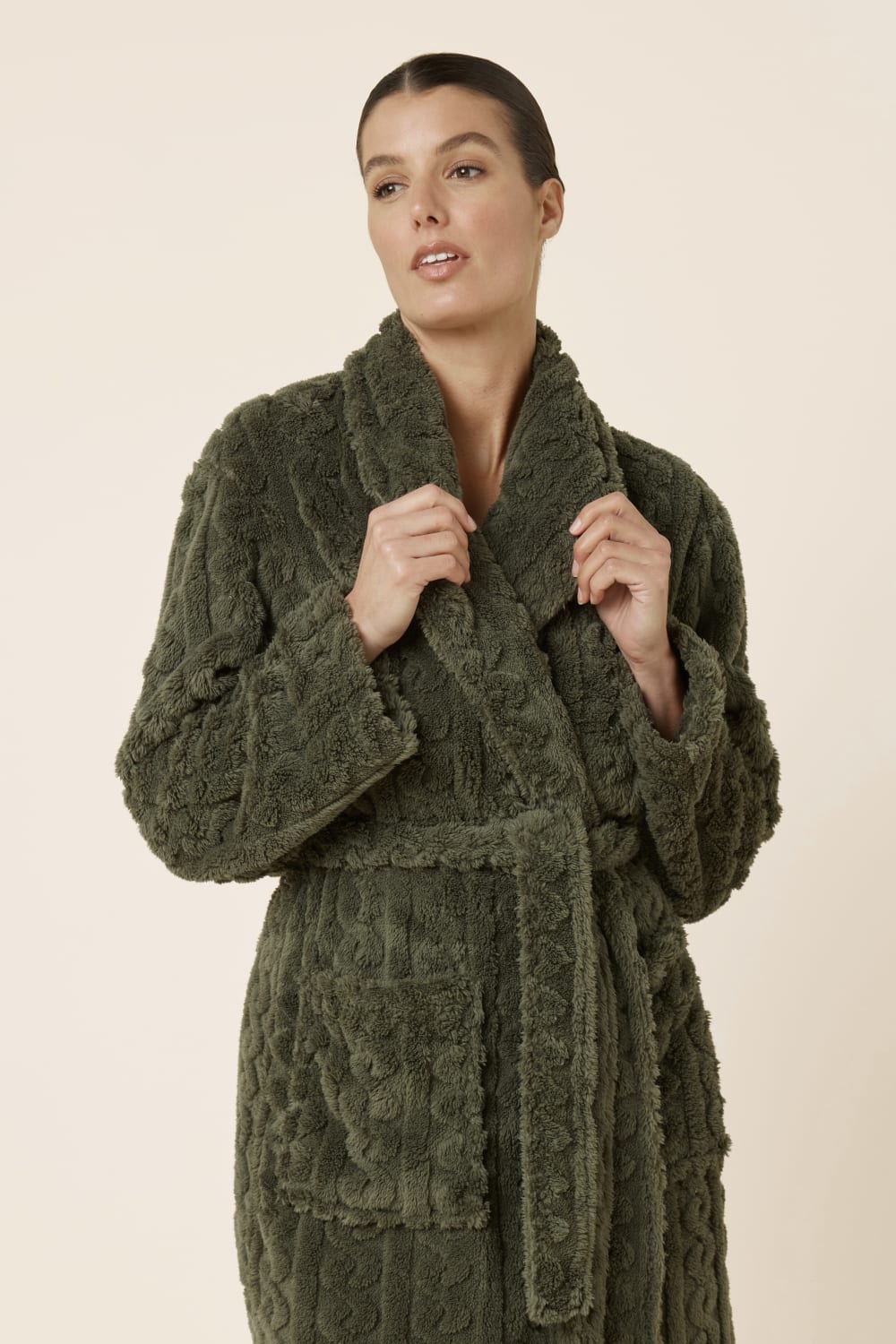 Woman wearing a tied up green olive Gabriella Plush Long Robe holding the neckline