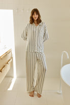 Woman in Harlow Bamboo Striped pyjama PJ Set Ivory model standing in a modern bathroom.