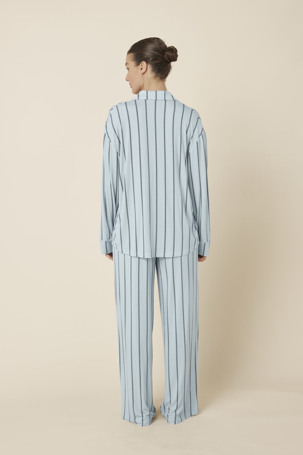 Woman wearing a light blue Harlow Bamboo Striped pyjama PJ Set from a back view