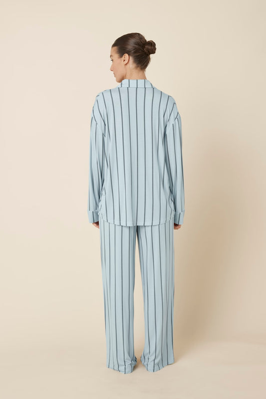 Woman wearing a light blue Harlow Bamboo Striped pyjama PJ Set from a back view