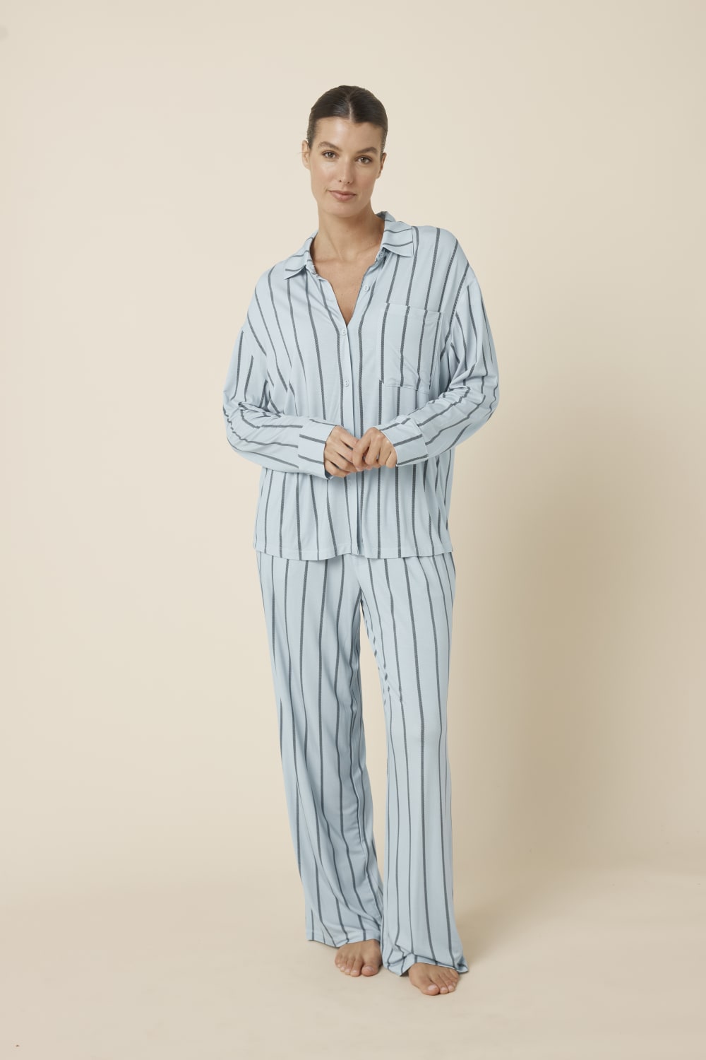 Woman wearing a light blue Harlow Bamboo Striped pyjama PJ Set from a front on view with hands together