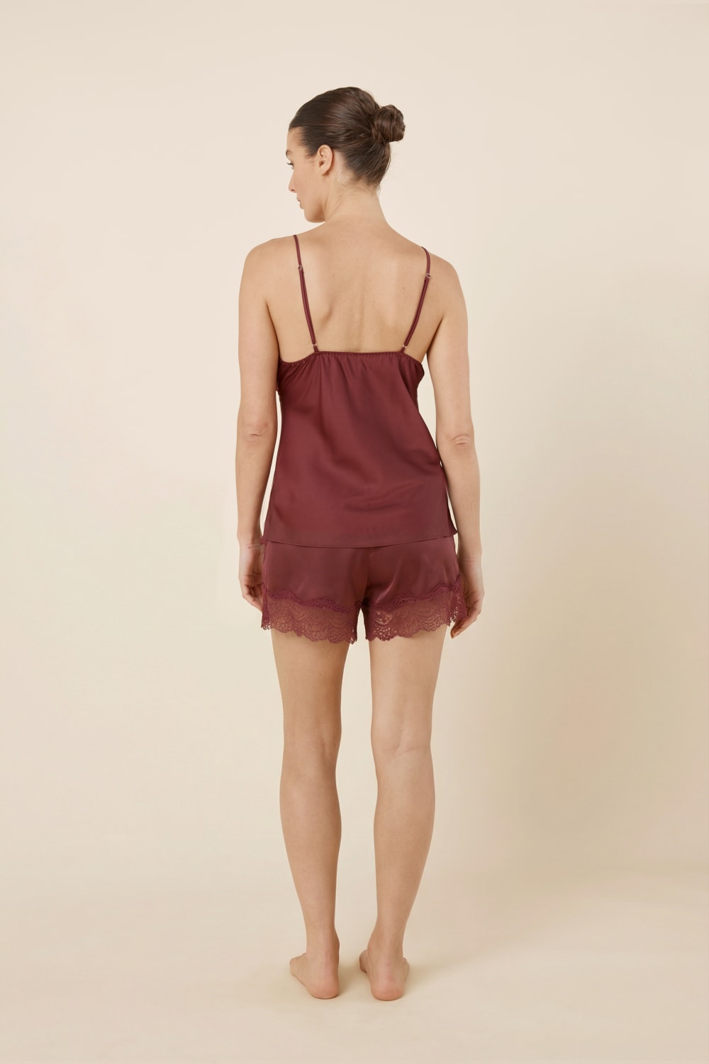 Back view of a woman wearing a Heather Silky Satin Cami and Short Set burgundy colour