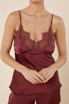 Close up torso front view of a woman wearing the burgundy heather silky satin cami and short set