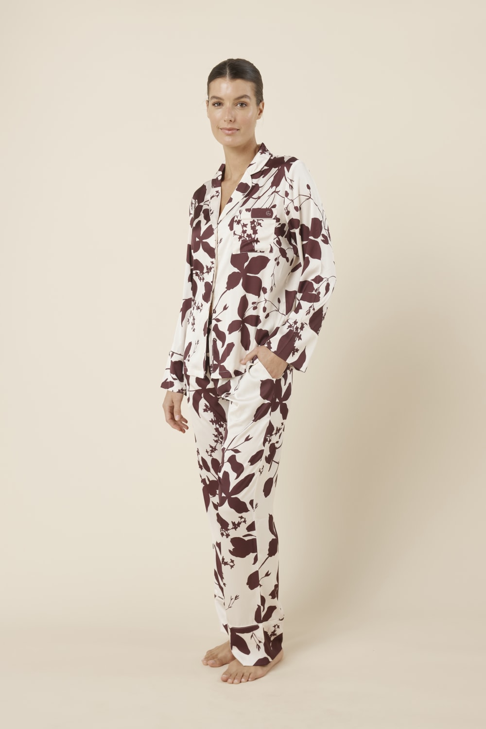 Woman wearing a ivy silky satin pyjama PJ set with floral pattern from side on view