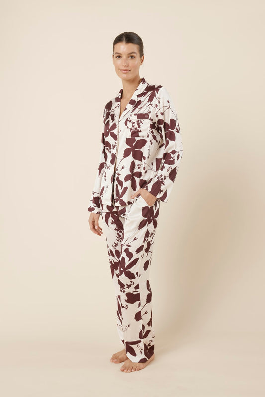 Woman wearing a ivy silky satin pyjama PJ set with floral pattern from side on view