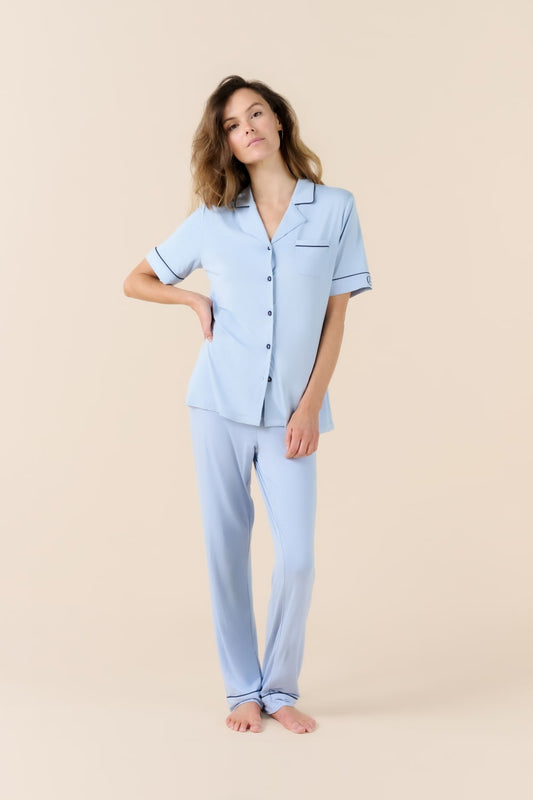 Woman wearing light blue pajamas against a beige background