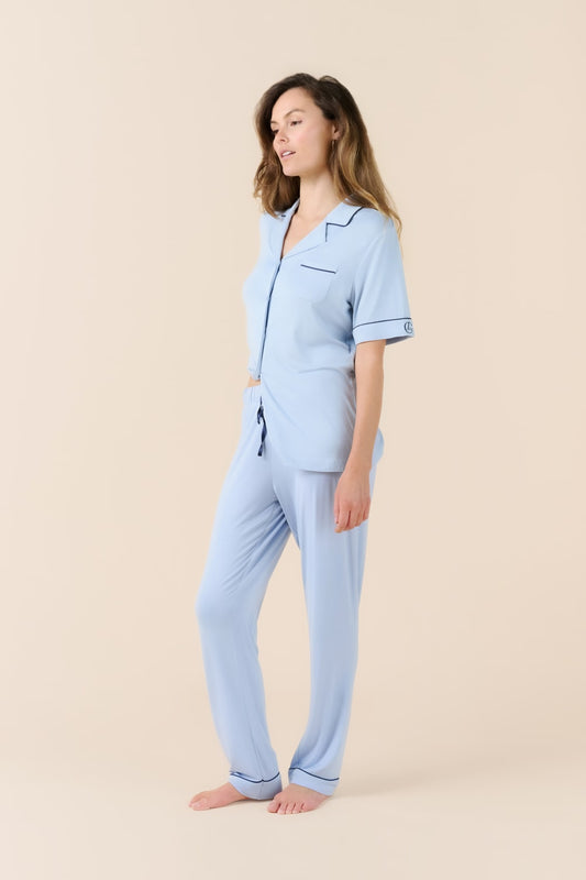 Woman wearing a light blue pajama set on a beige background