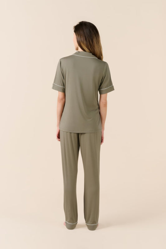 Woman wearing a green pajama set on a beige background