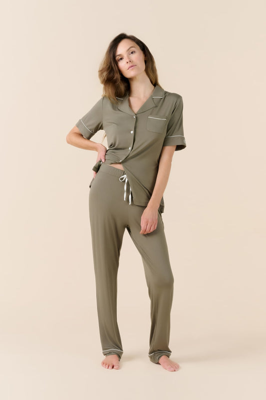 Woman wearing a green pajama set on a beige background