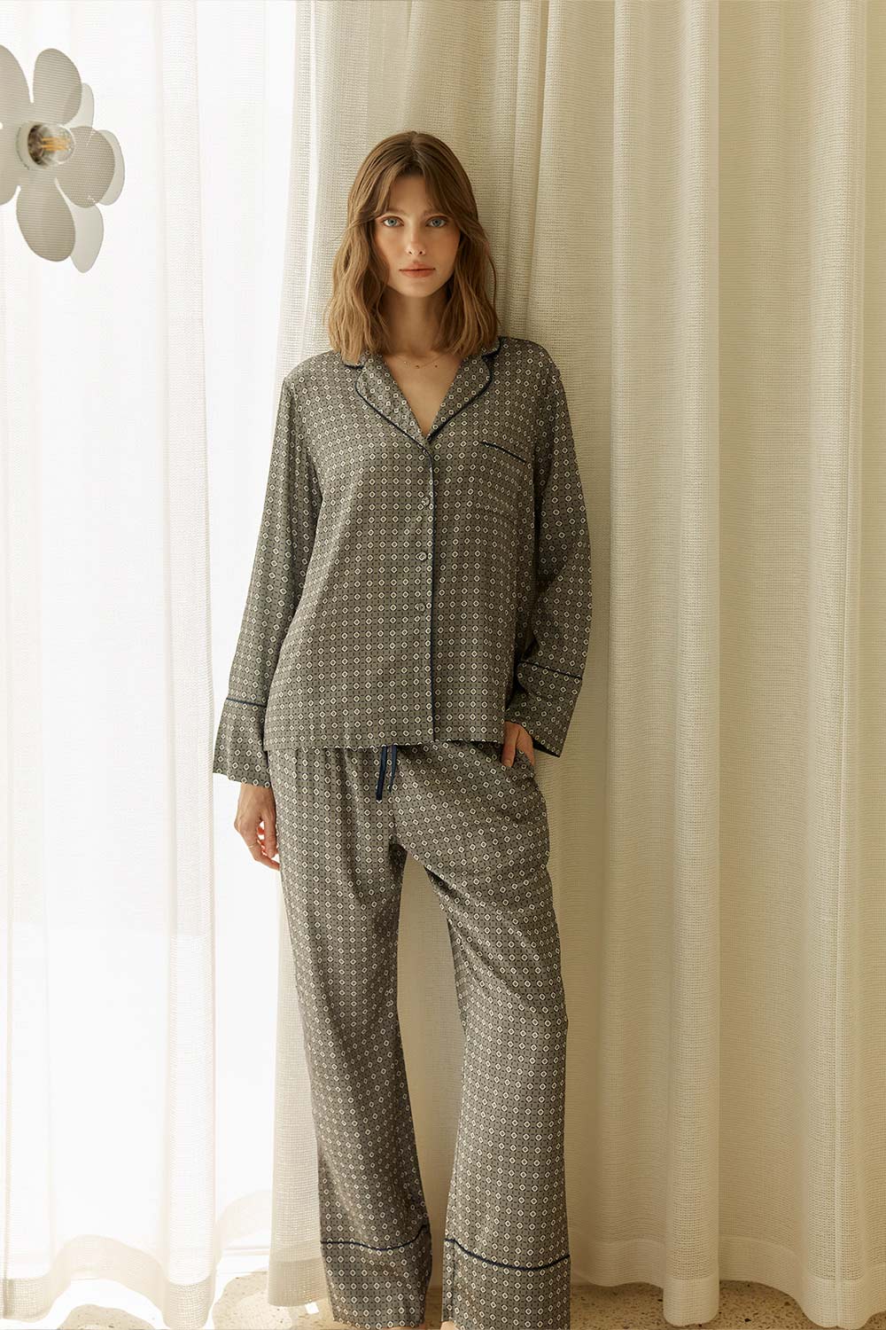 Woman wearing Kienna Geo Printed Silky Satin PJ Set standing in front of a curtain.