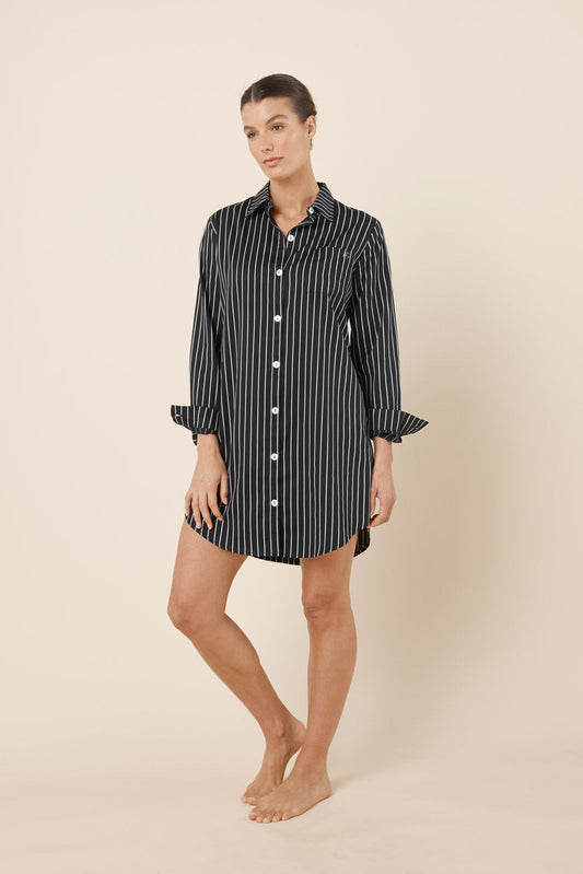 Woman wearing a black and white striped shirt dress on a beige background