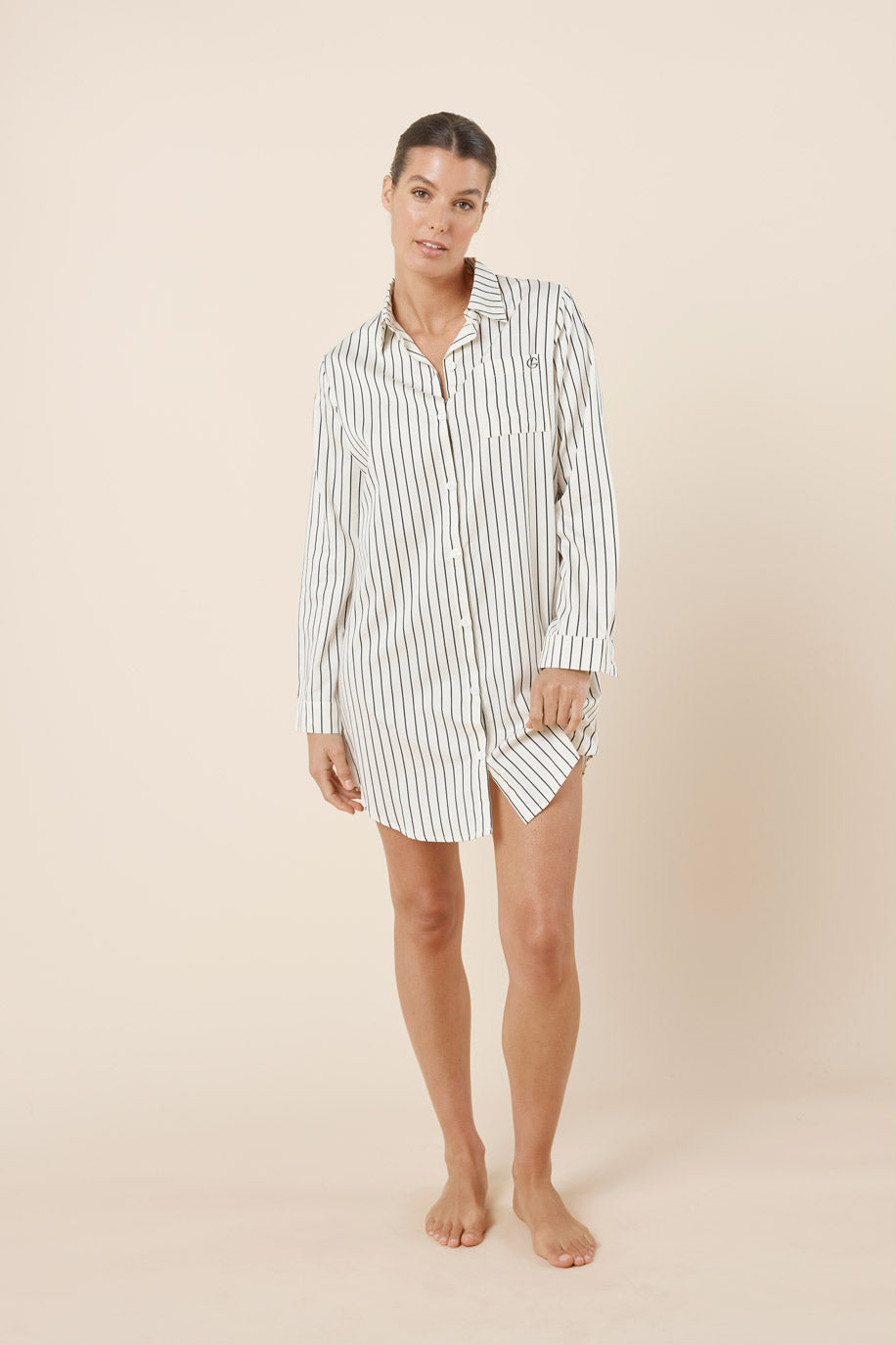 Woman wearing a striped nightshirt on a beige background