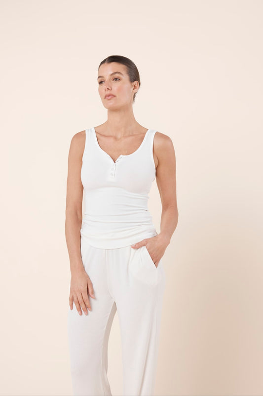 Woman wearing Liberty Ribbed Singlet Henley Top Ivory styled with relaxed ribbed lounge pants