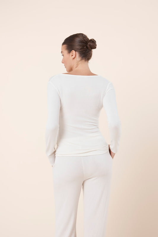 Woman wearing Lille Ribbed Long Sleeve Henley Top Ivory Ecru back view showing slim fit ribbed silhouette