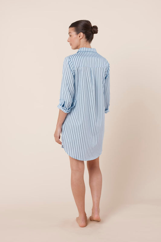 Woman wearing a blue striped Lolita Stripe Night Shirt dress against a beige background back view