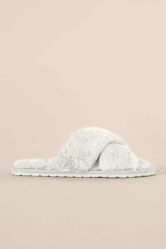 Pair of fluffy Milan Plush Slipper Ivory slippers on a beige background from side view