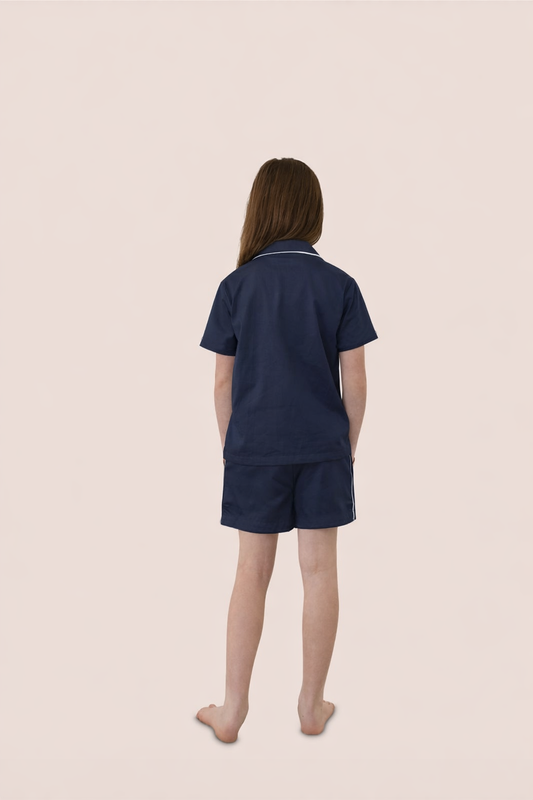 Person wearing navy blue pajamas on a beige background