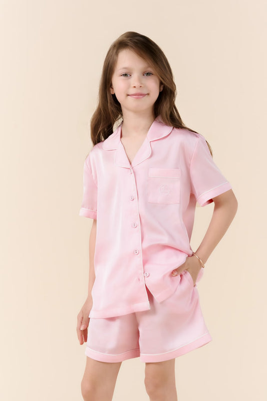 Young girl wearing a pink pajama set on a beige background