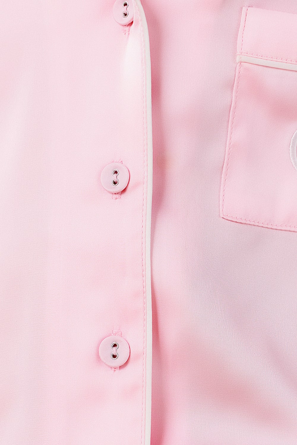 Close-up of a light pink shirt with buttons and a pocket.