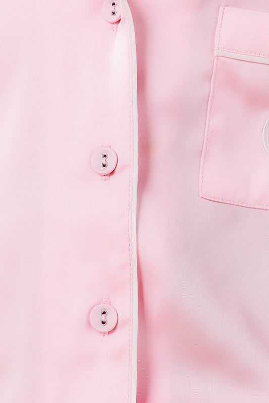 Close-up of a light pink shirt with buttons and a pocket.