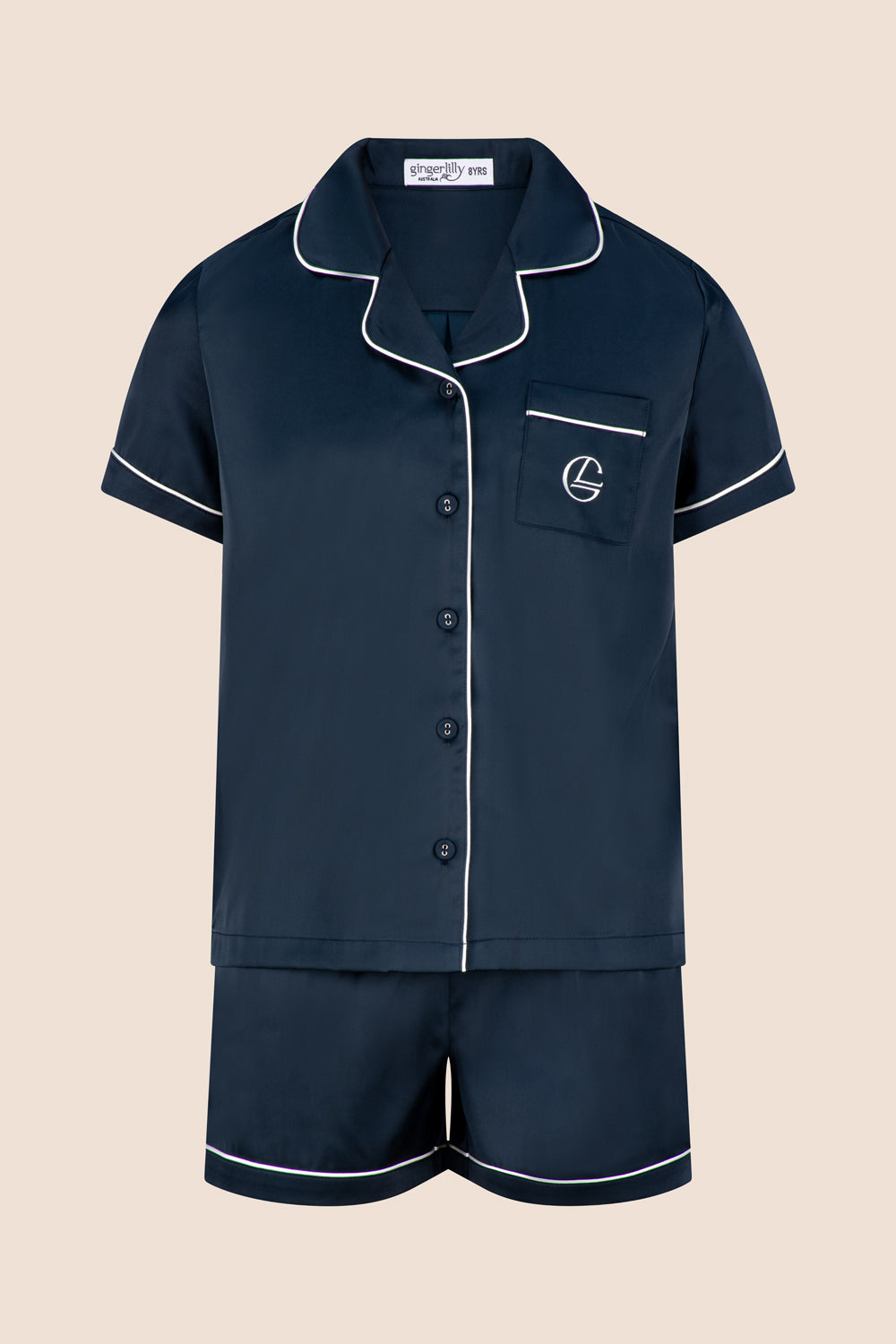 Navy pajama set with white piping on a beige background