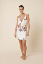 Woman wearing a Piper Floral Silky Satin Nightie Ivory dress against a beige background front view