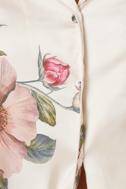 Close-up of Ruby Floral Satin PJ set Ivory detail floral pattern, on garment with pink flowers and green leaves.