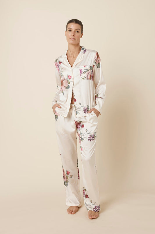 Woman wearing a Ruby Floral Satin PJ set Ivory front view against a plain background