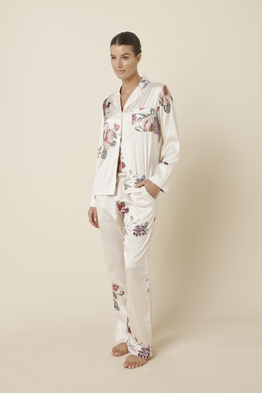 Woman wearing a Ruby Floral Satin PJ set Ivory side view against a plain background