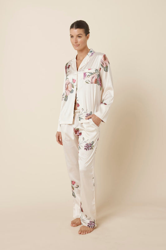 Woman wearing a Ruby Floral Satin PJ set Ivory side view against a plain background